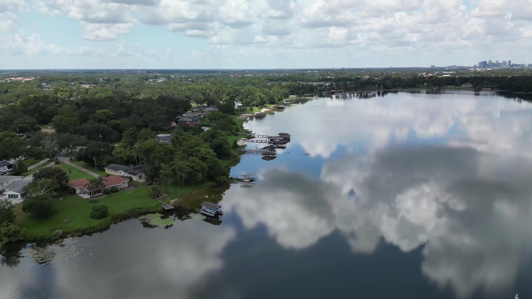 Aerial view of a Central Florida lakefront neighborhood with the Orlando skyline on the horizon